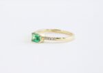 Small emerald cut emerald in 18k gold and side diamonds