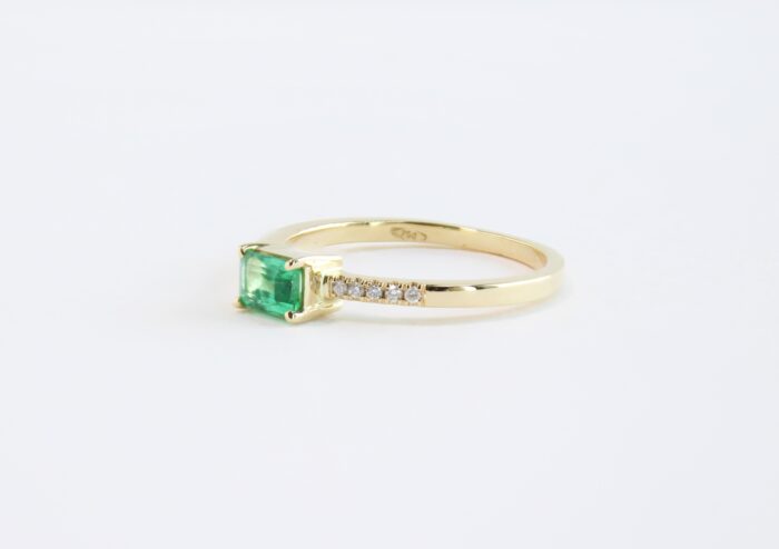 Small emerald cut emerald in 18k gold and side diamonds